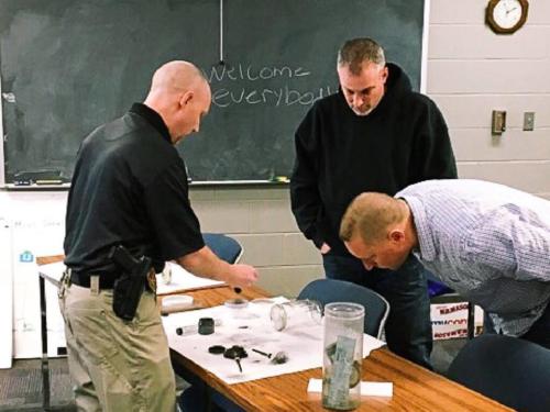 Det. Scott Roberts (left) teaching fingerprinting techniques 